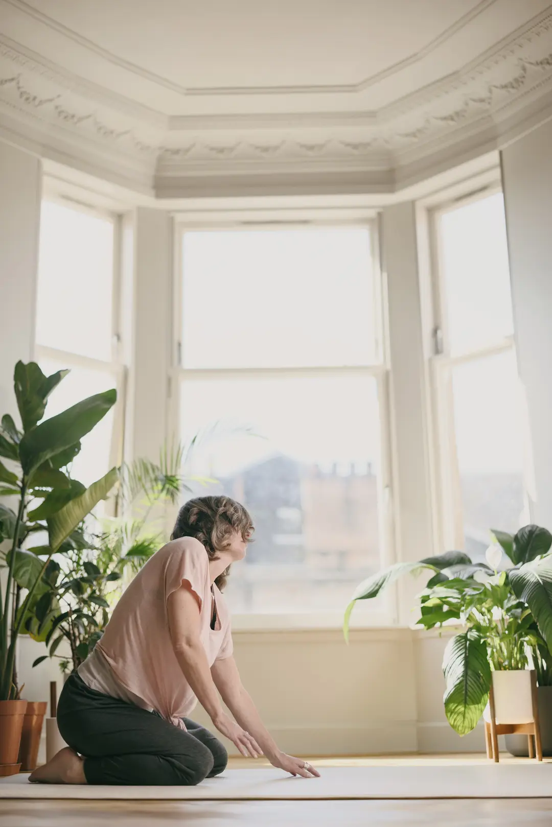 Nicki on a mat beside a bay window, moving slowly