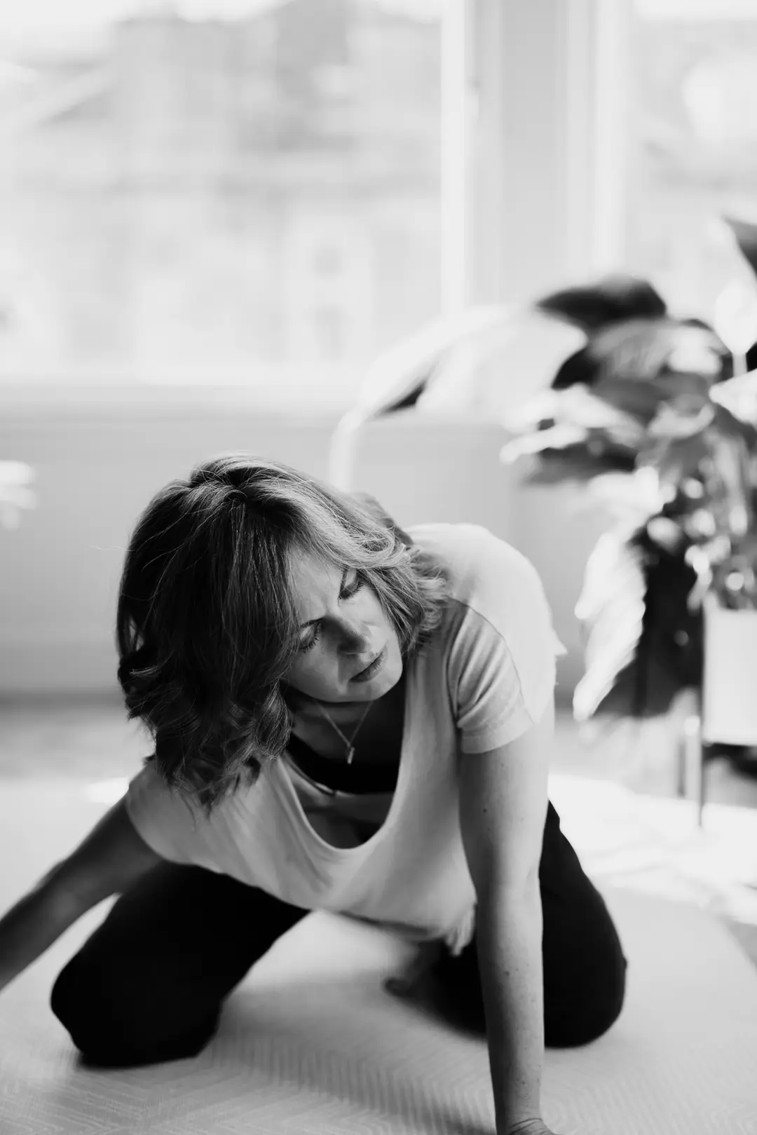 Nicki kneeling and looking up, smiling, in a bright studio